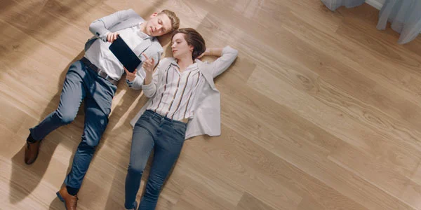 man en vrouw liggen op parket | man and woman lying on parquet