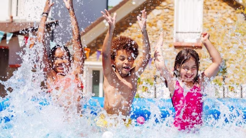 een groep kinderen die in een opblaasbaar zwembad spelen | un groupe d'enfants jouant dans une piscine gonflable