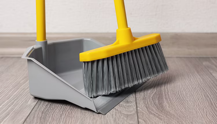 schoonmaken met stoffer en blik