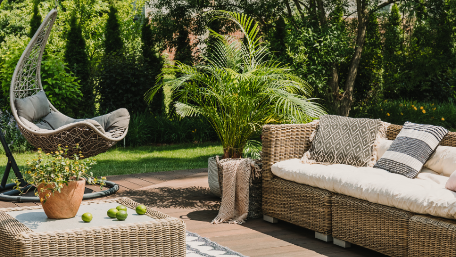 Een terras met rieten meubels en potplanten | Un patio avec des meubles en osier et des plantes en pot