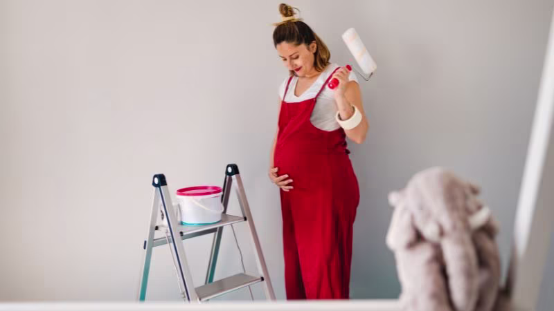 Zwangere vrouw schildert babykamer met verfroller | Femme enceinte peignant une chambre
