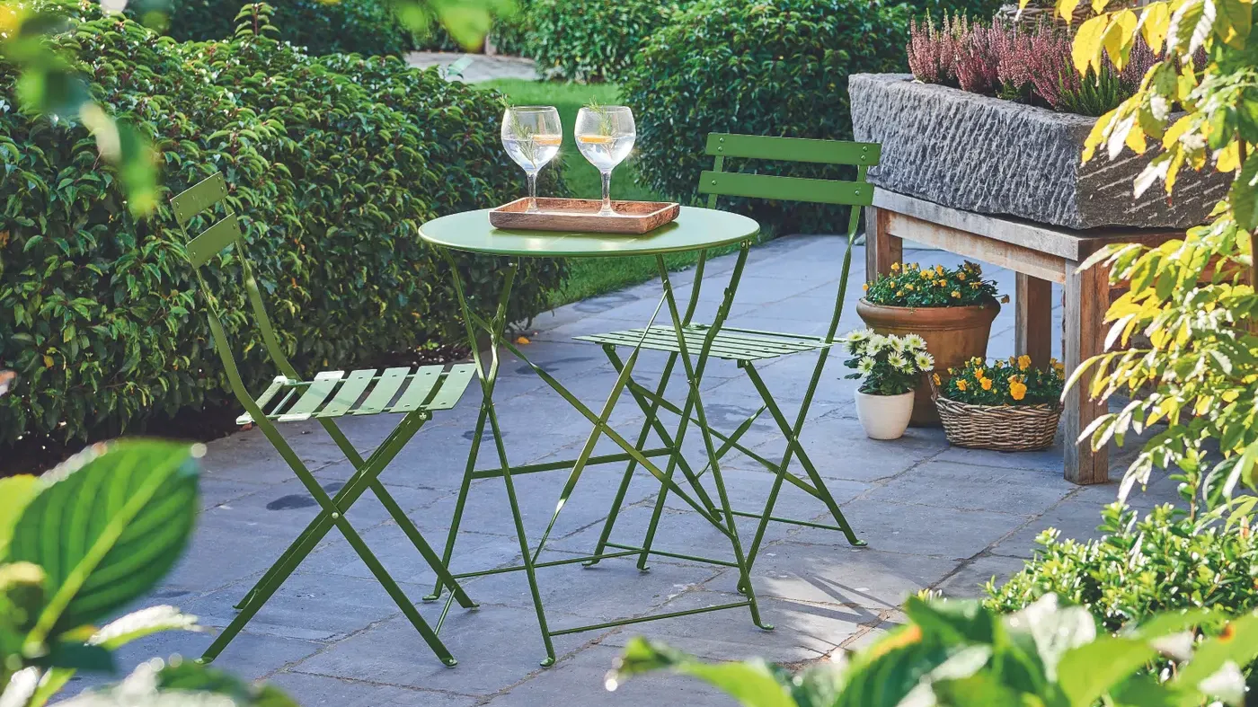 set chaise et table bistro sur une terasse dans un jardin | stoel en bistrotafel op een tuinterras