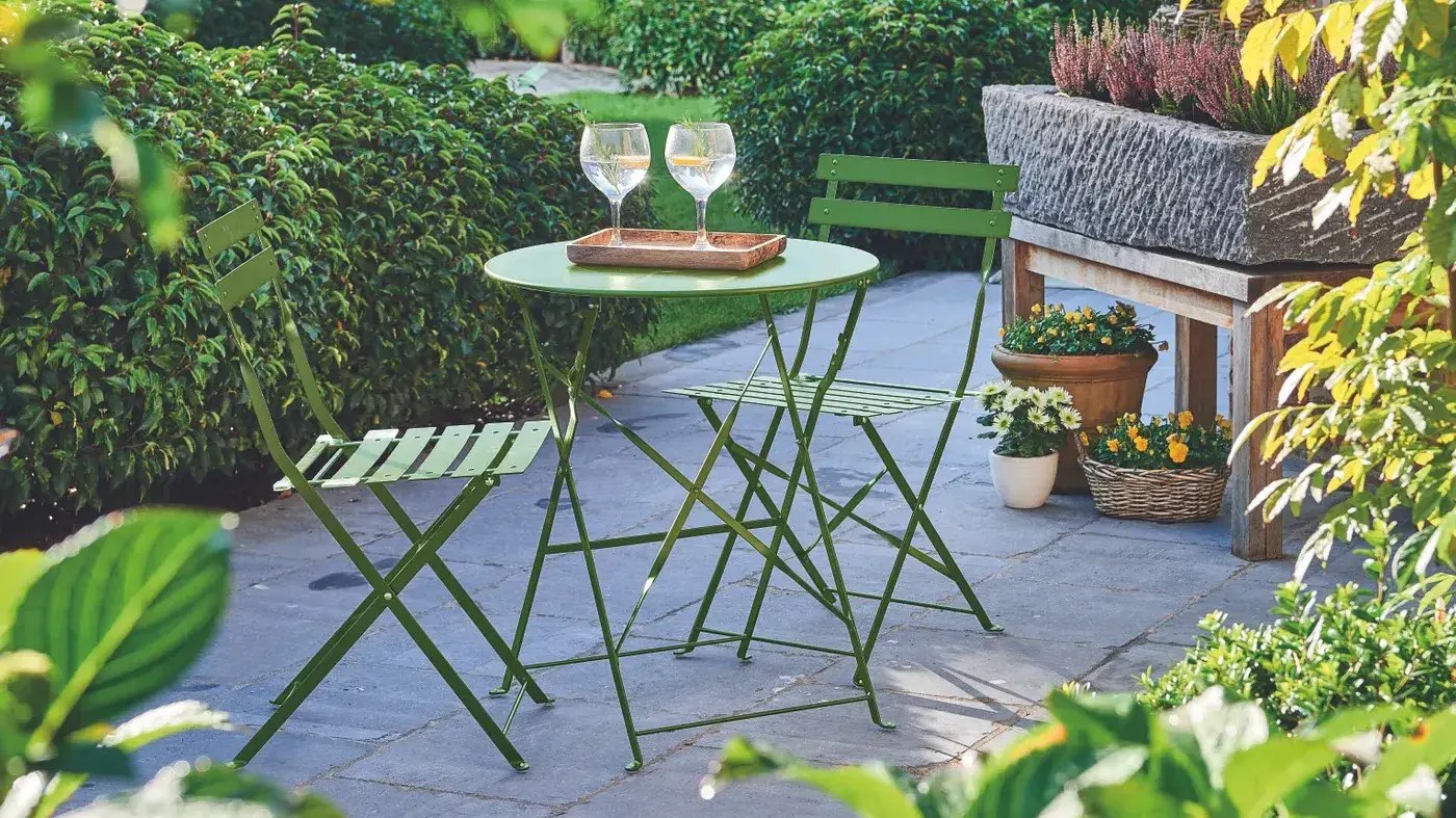 set chaise et table bistro sur une terasse dans un jardin | stoel en bistrotafel op een tuinterras