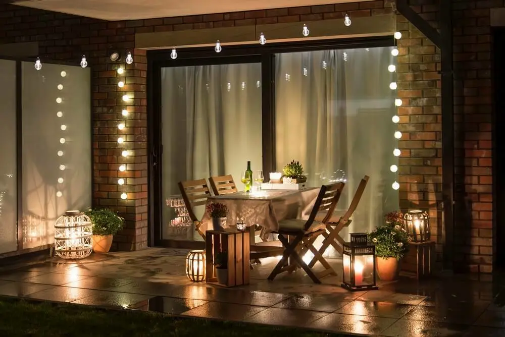 Een tuinset op het terras met lichtjes en kaarsen | Un jardin sur la terrasse avec des lumières et des bougies