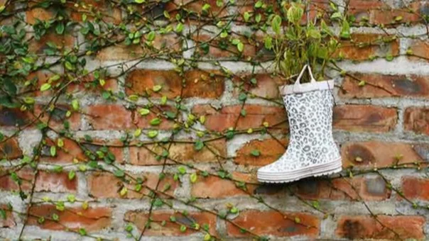 Een regenlaars hangt aan de muur | Une botte de pluie est accrochée au mur