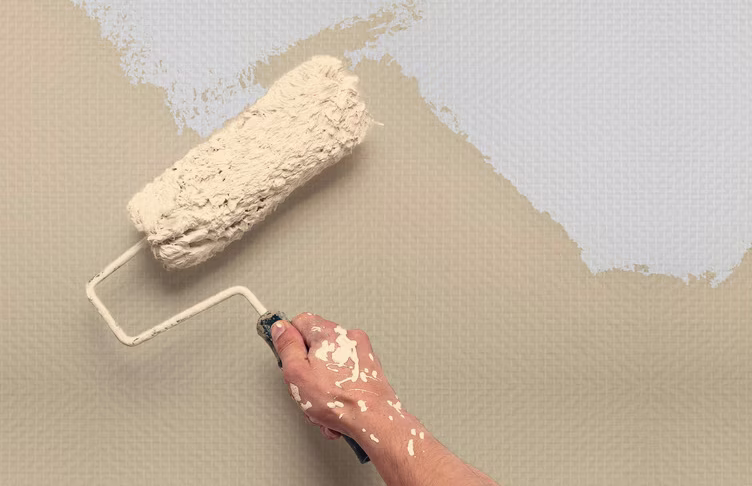 Beige verf met verfroller op behang