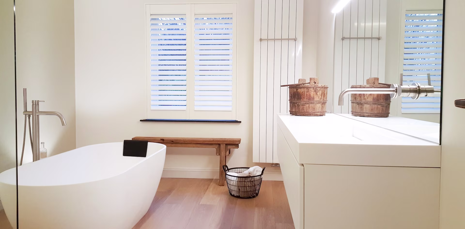 badkamer met wit bad, houten accesssoires en een badkamervloer van laminaat badkamer met wit bad, houten accesssoires en een badkamervloer van laminaat