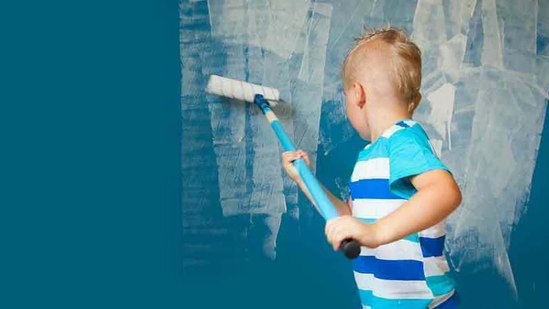 Een kindje verft de blauwe muur wit | Un enfant peint le mur bleu en blanc 