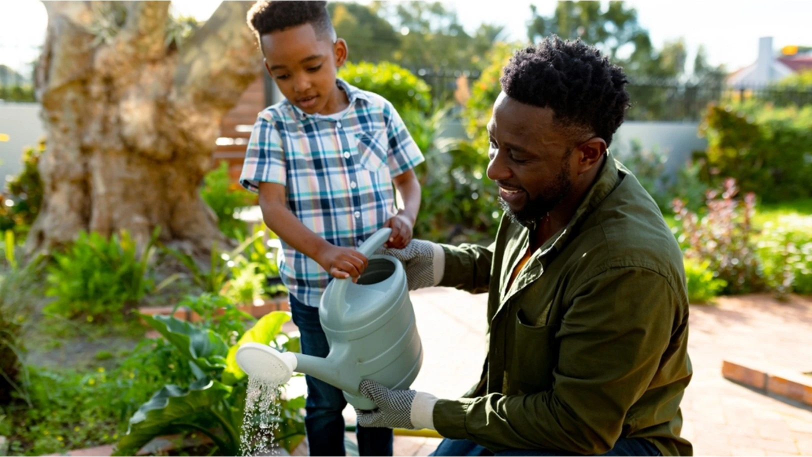 Kind en man geven een tuin water | Enfant et homme qui arrose un jardin