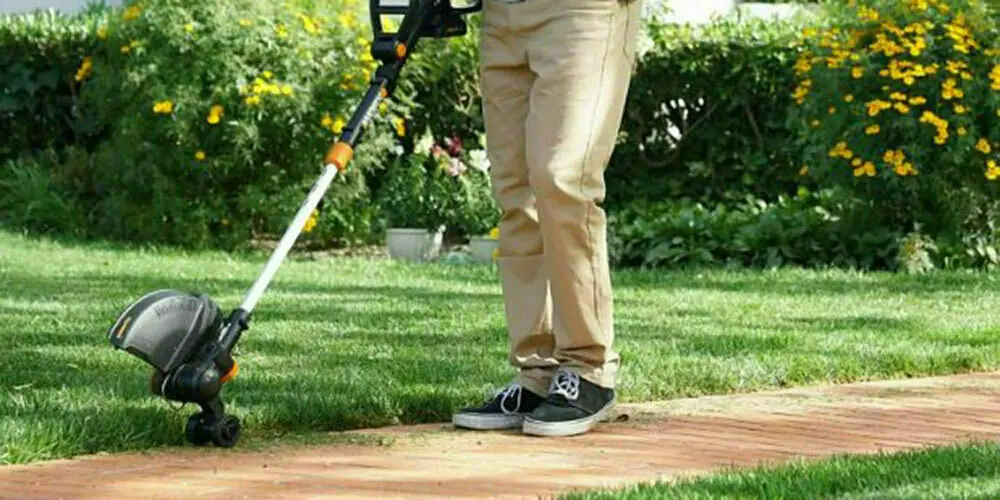 Man met grastrimmer | Homme avec un coupe-herbe