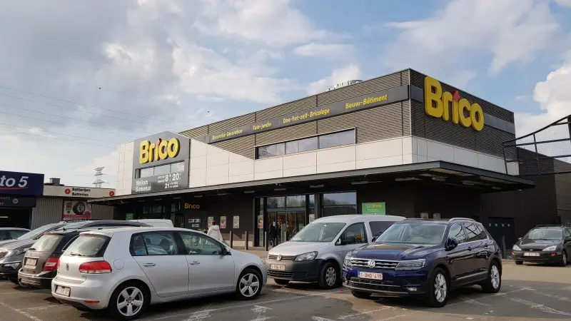 Een Brico winkel met geparkeerde auto's op de parkeerplaats | Un magasin Brico avec des voitures garées sur le parking