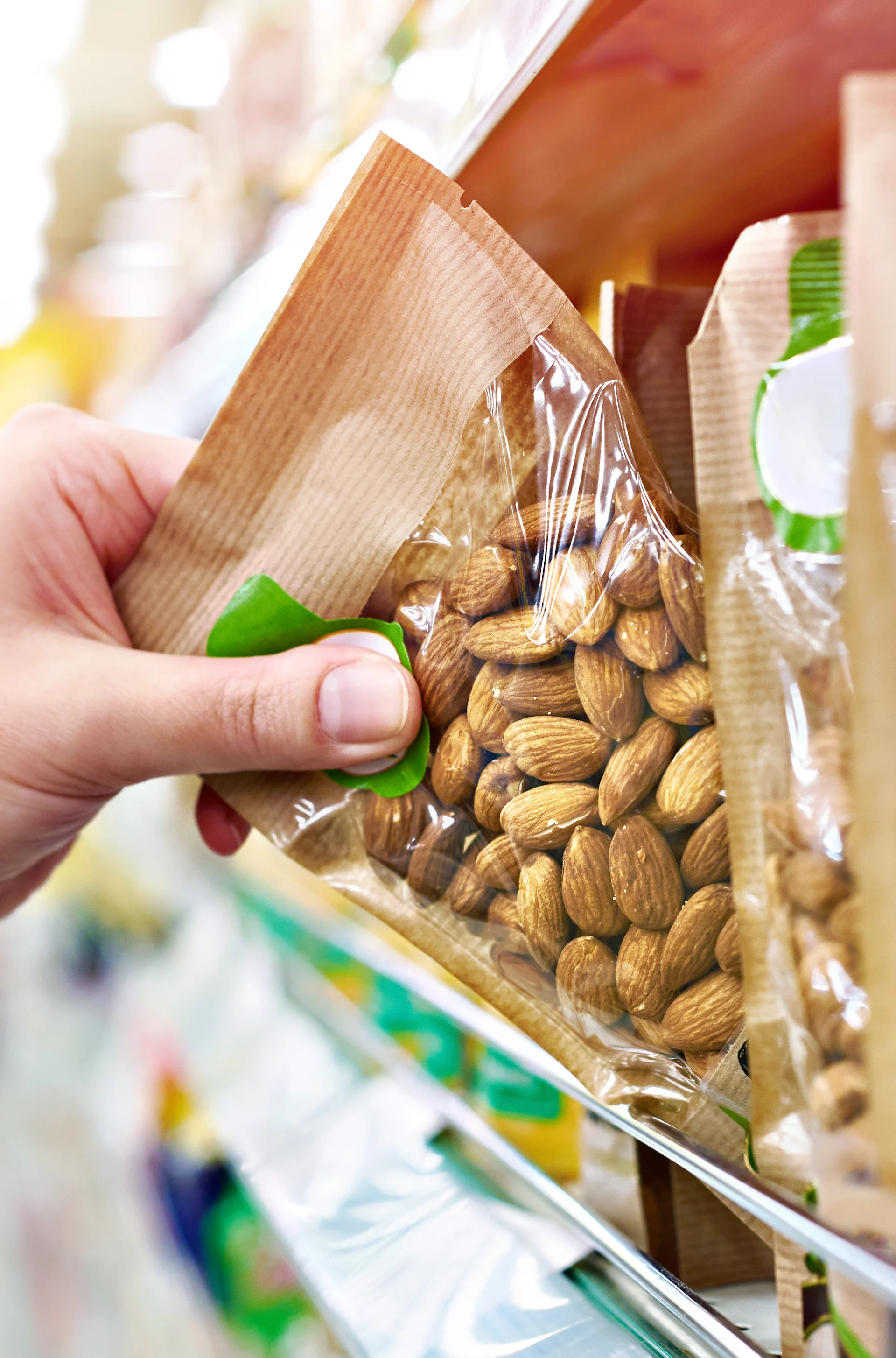 Customer selecting packaged almonds in a retail aisle, with flexible food packaging Customer selecting packaged almonds in a retail aisle, with flexible food packaging