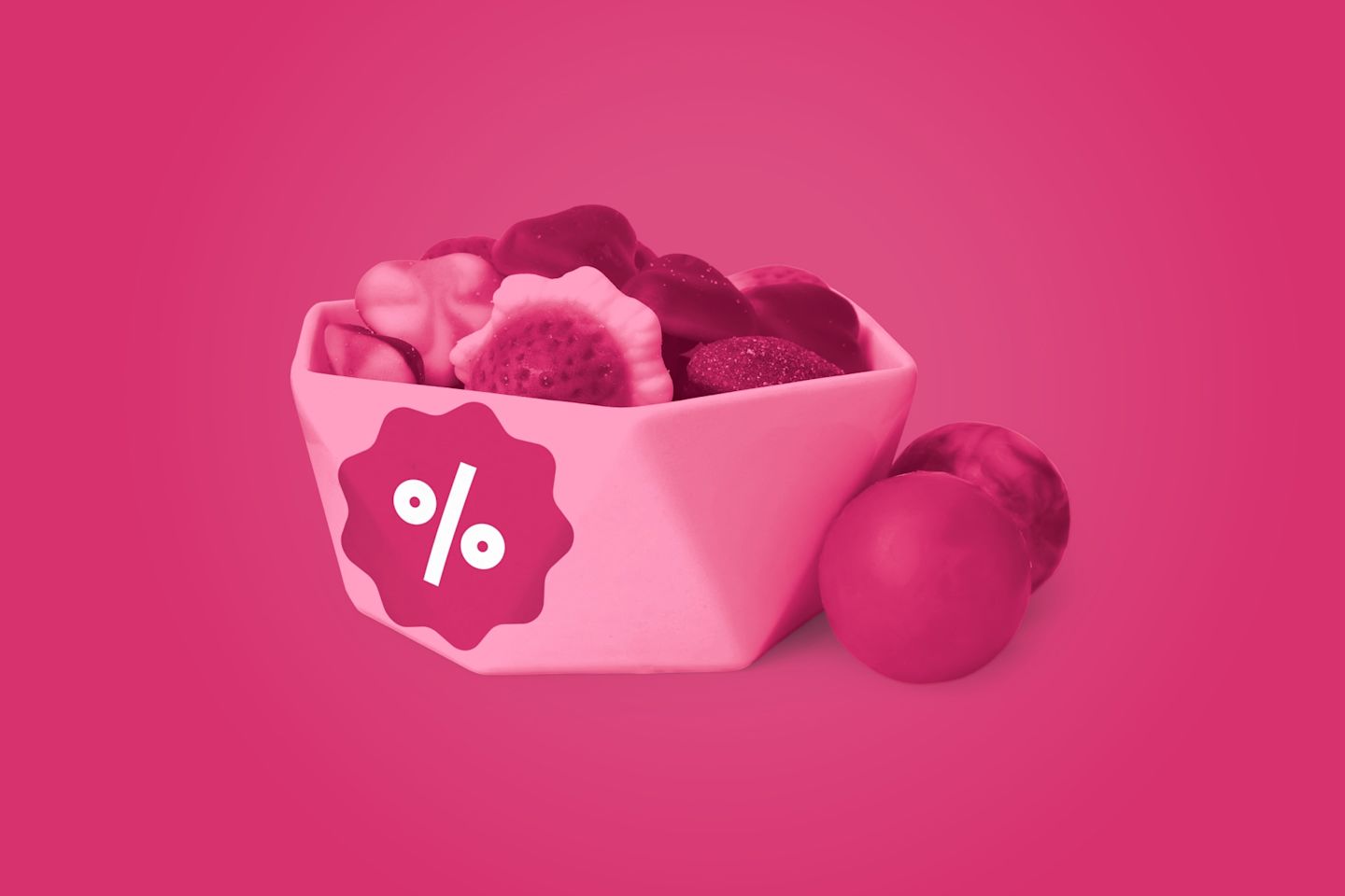 Vaaleanpunainen kulho täynnä karkkeja, joissa on tarjousmerkki, vaaleanpunaisella taustalla.