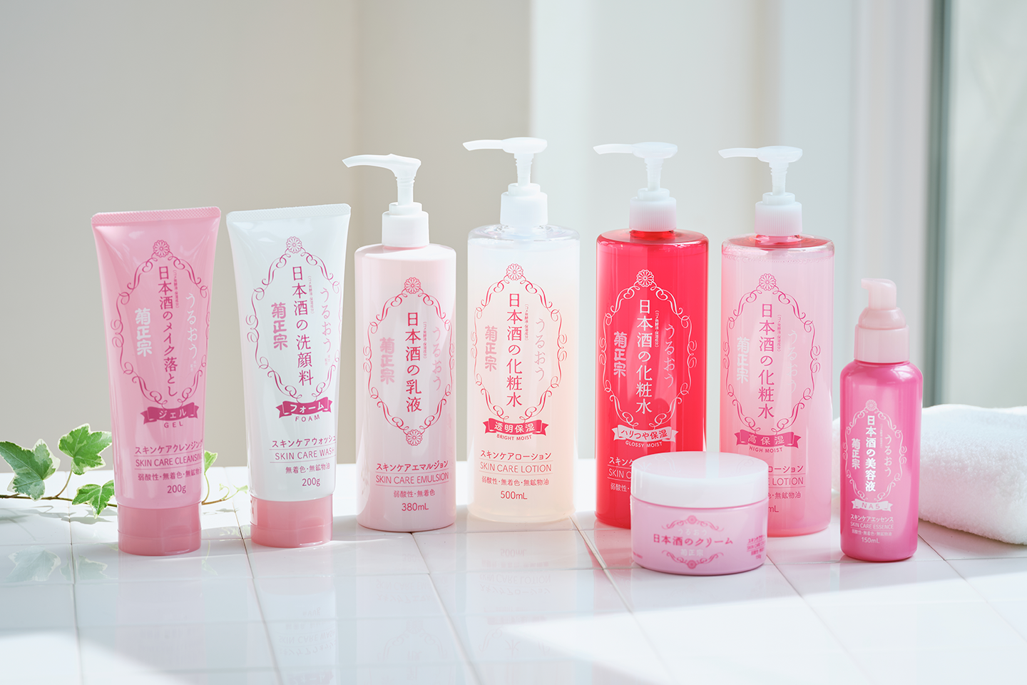 Vaaleanpunainen japanilainen ihonhoitosarja valkoisella pinnalla – erilaisia puhdistustuotteita ja kosteusvoiteita raikkaassa asetelmassa.