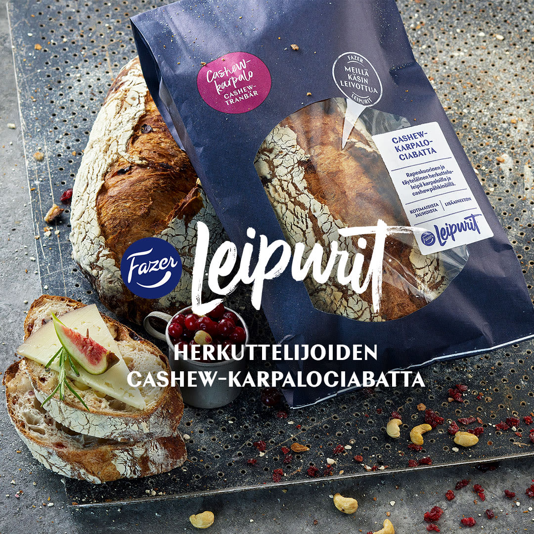 Fazer Leipurit cashew-karpalociabatta pakkauksessaan, vieressä leikattuja leipäviipaleita juuston ja viikunan kera.