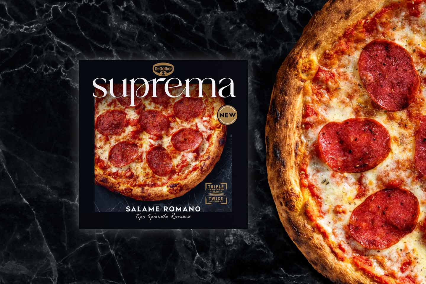 Tummalla kivitasolla pizzapakkaus, jonka kannessa on salamipizza ja vieressä puolikas salamipizza.