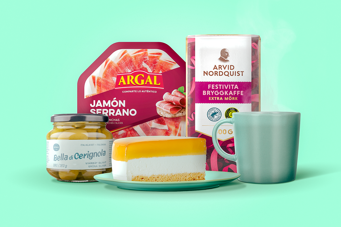 Herkullinen asetelma, jossa juustokakku, oliivit, serranokinkku, kahvipaketti ja muki vihreällä taustalla.