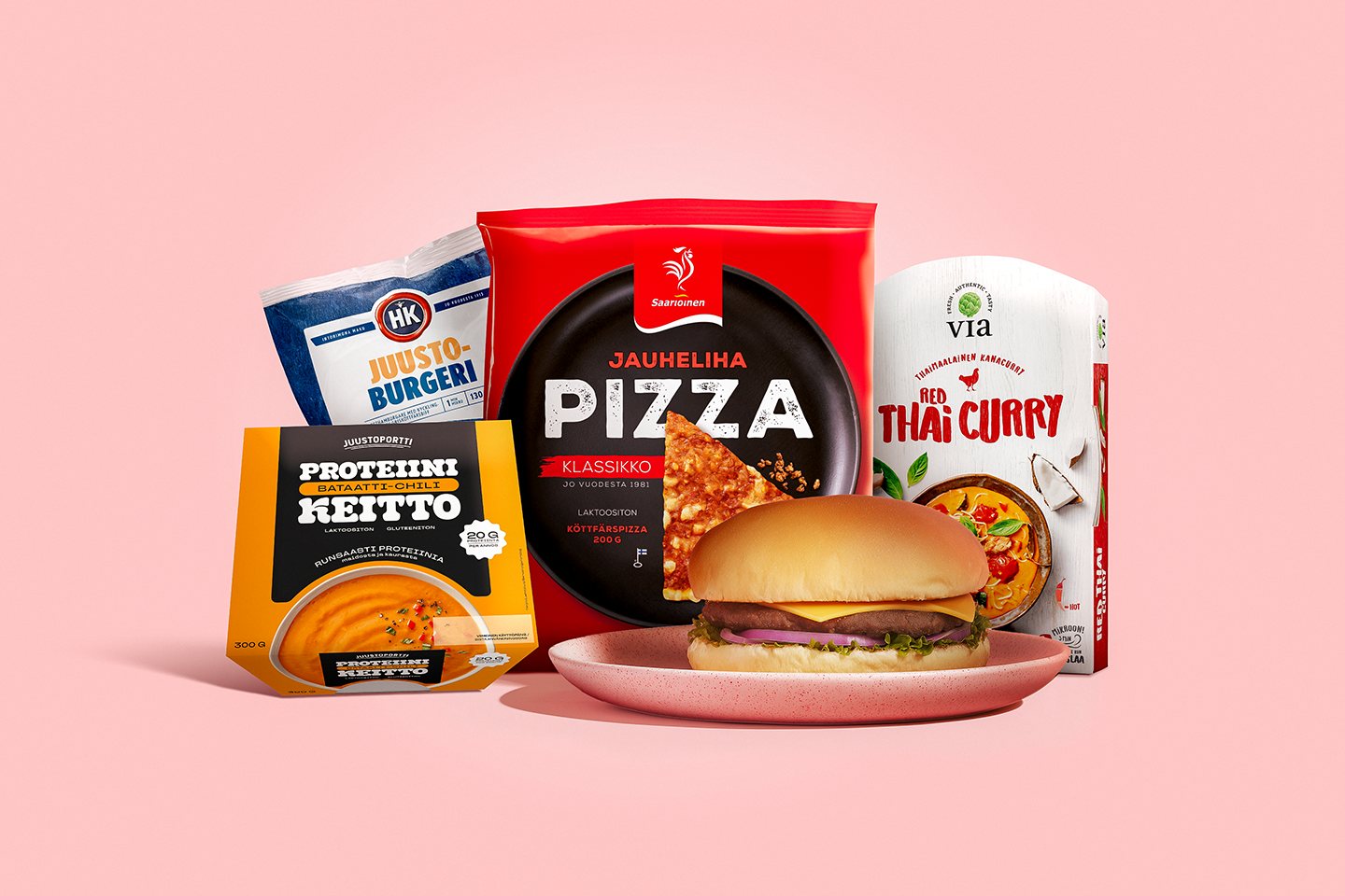 Hampurilainen lautasella ja erilaisia valmisruokapakkauksia kuten pizza, juustoburgeri, proteiinikeitto ja thai curry vaaleanpunaisella taustalla.