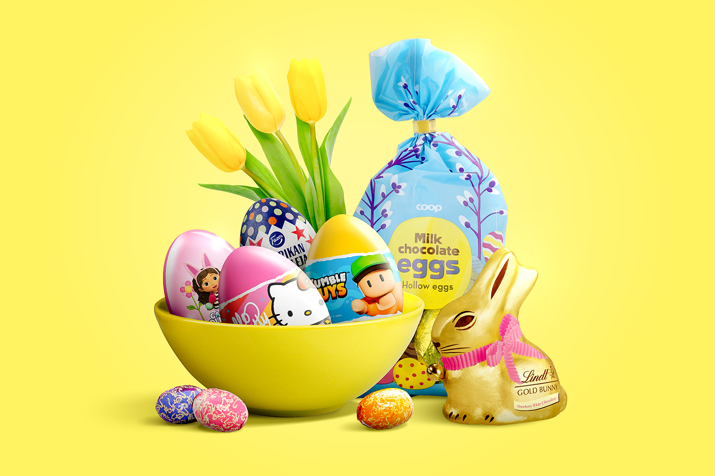Iloinen pääsiäisasetelma keltaisella kulholla, jossa on värikkäitä suklaamunia, tulppaaneja ja Lindt-suklaapupu.