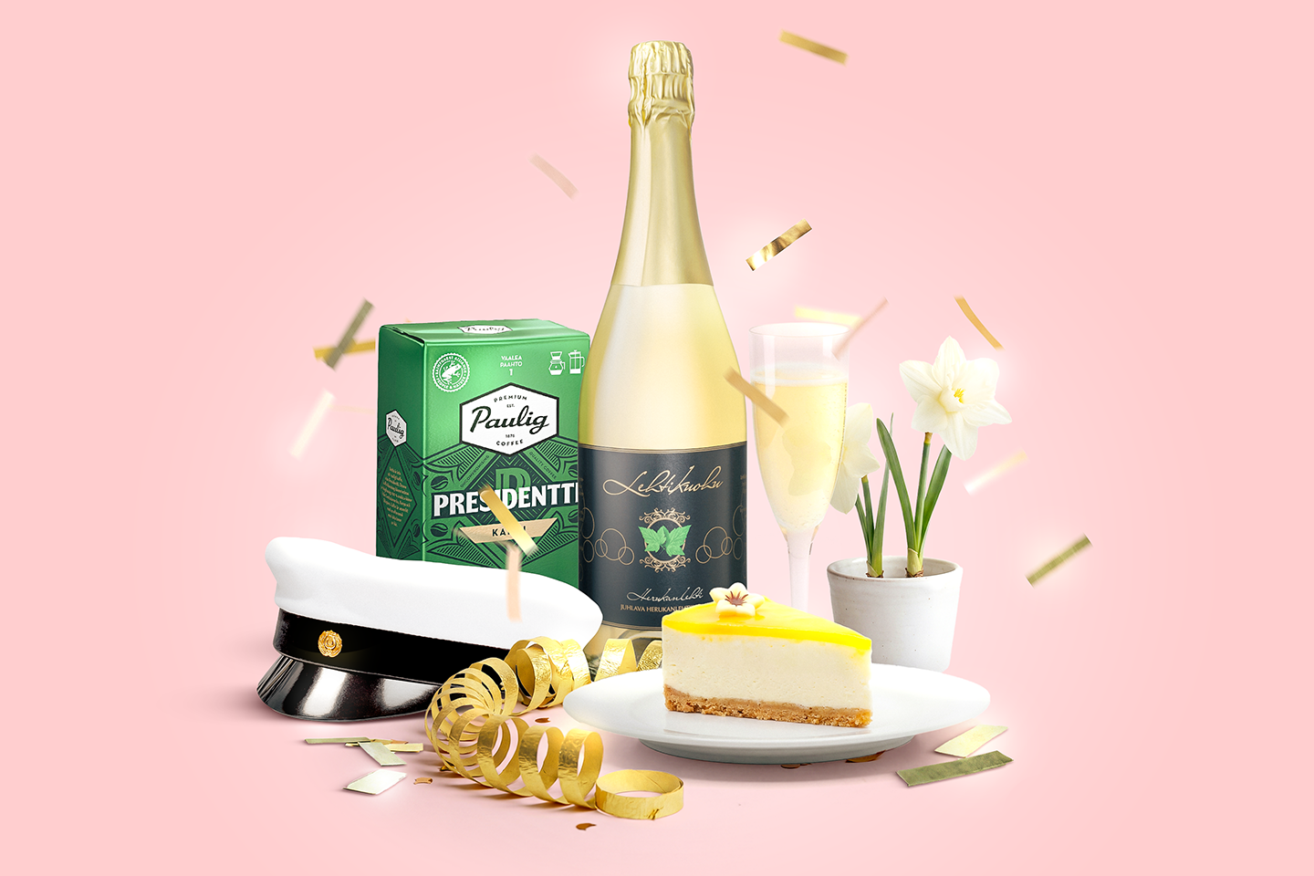Juhlavaa asetelmaa vaaleanpunaisella taustalla: samppanjapullo, juhlakakku, Presidentti-kahvipaketti, ylioppilashattu ja narsissi kultaisilla koristeilla.