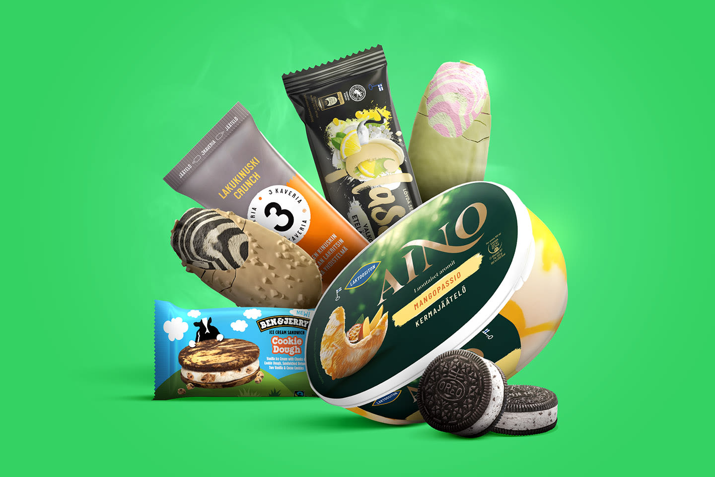 Herkullinen kokoelma jäätelöitä ja jäätelöherkkuja vihreällä taustalla, mukana Aino-jäätelöä, Ben & Jerry's -jäätelösandwich ja Oreo-keksejä.