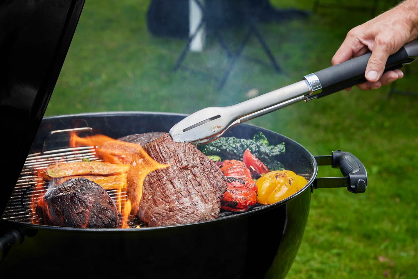 Pihvejä ja vihanneksia grillautumassa hiiligrillissä.