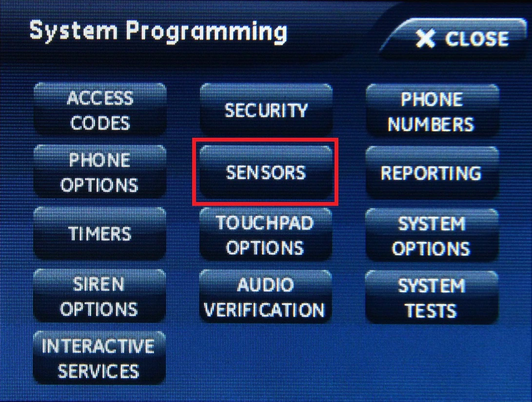 the Simon XTi programming menu with a red square around the sensors button