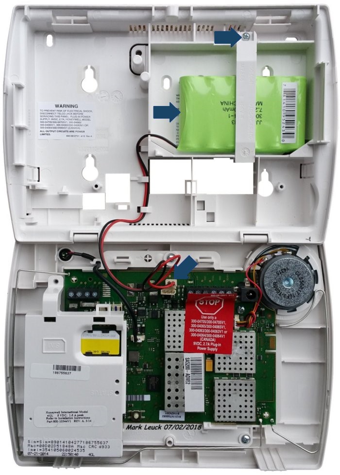 Picture of the inside of the Lynx Touch 5210 with an arrow pointing to the screw holding the backup battery in place, another arrow pointing to the battery itself, and a third arrow pointing to where the battery connector is