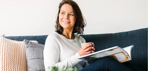 Woman sitting on a sofa with a mug