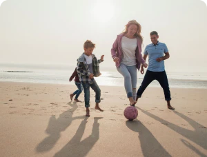 Family playing football on a beach