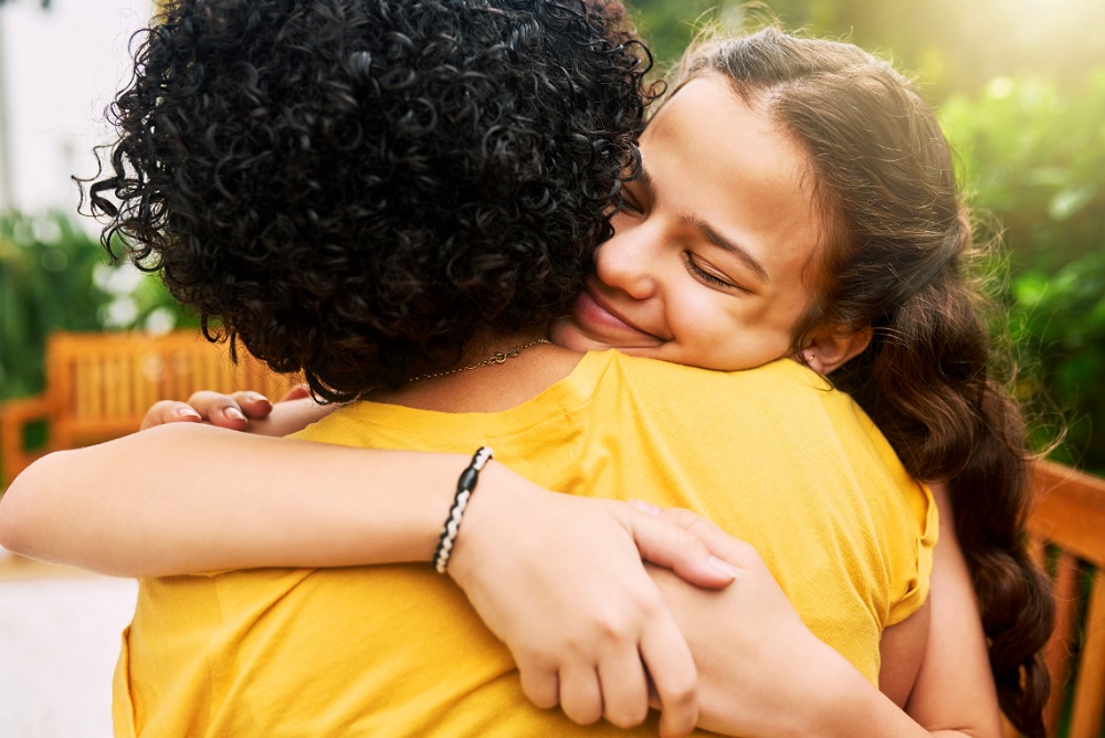 Picture of two individuals hugging in support.