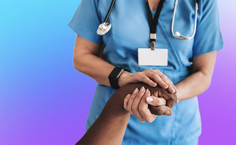 Nurse in blue scrubs holding hand of a patient