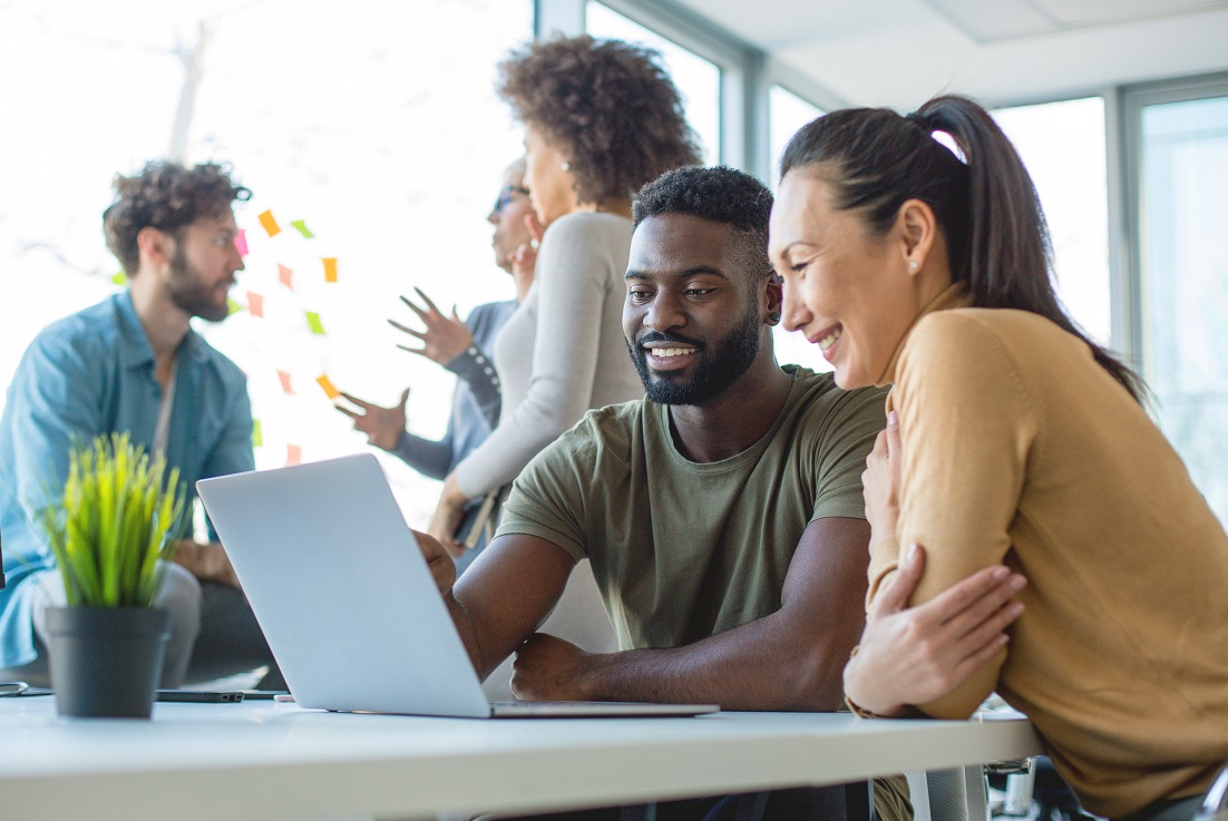 Picture of two professionals in an office setting looking at HSA plan options on a laptop