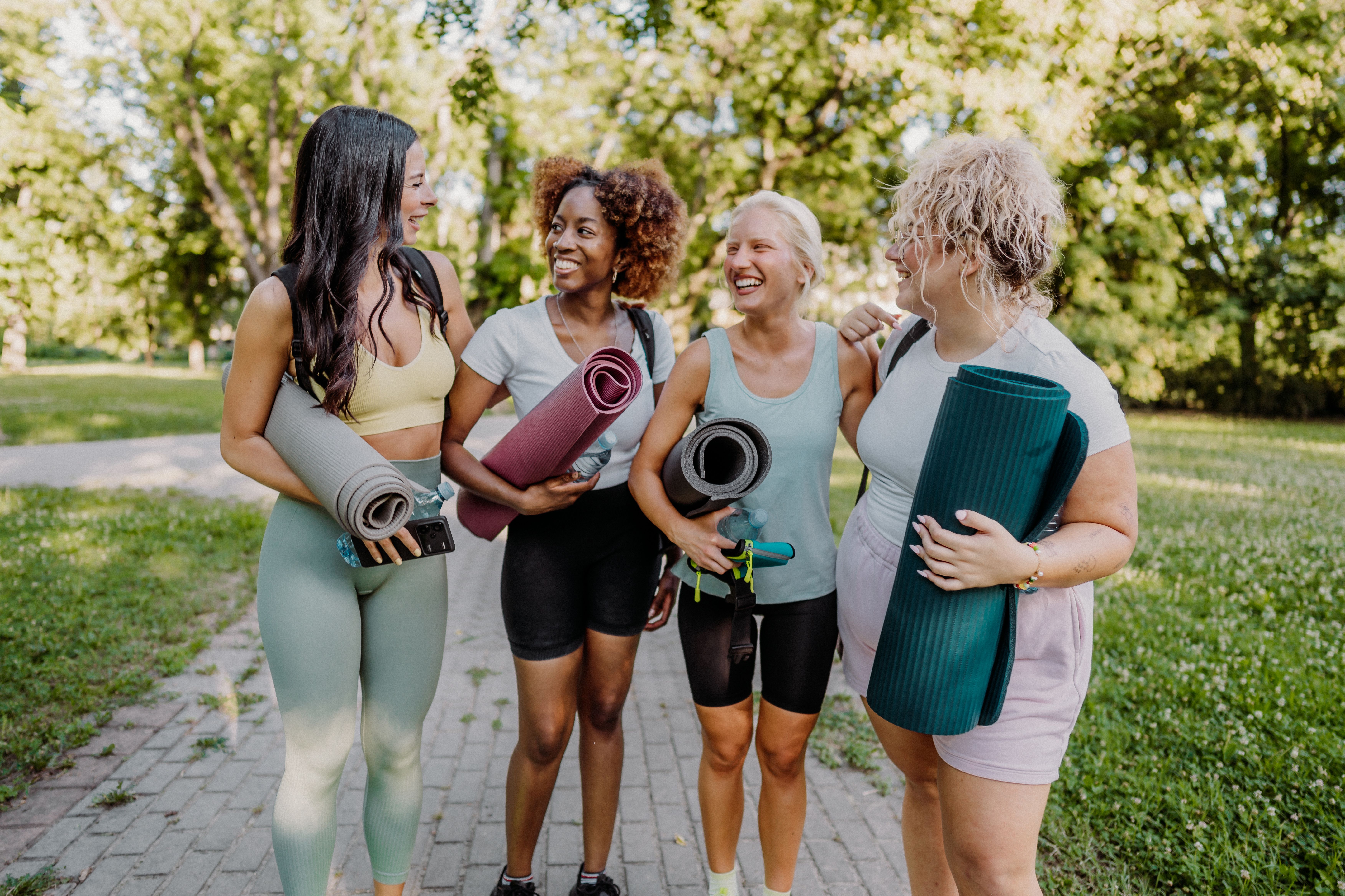 Women of different ages talk with another before a yoga class.