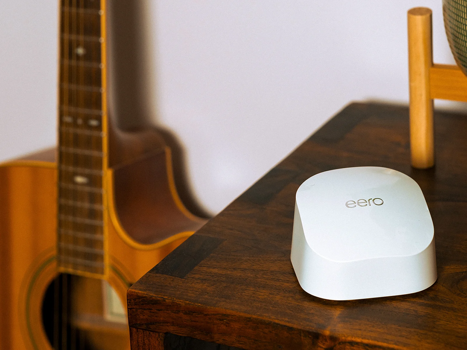 Eero Wi-Fi device positioned on a wooden table, representing whole-home Wi-Fi coverage and reliable broadband connectivity.