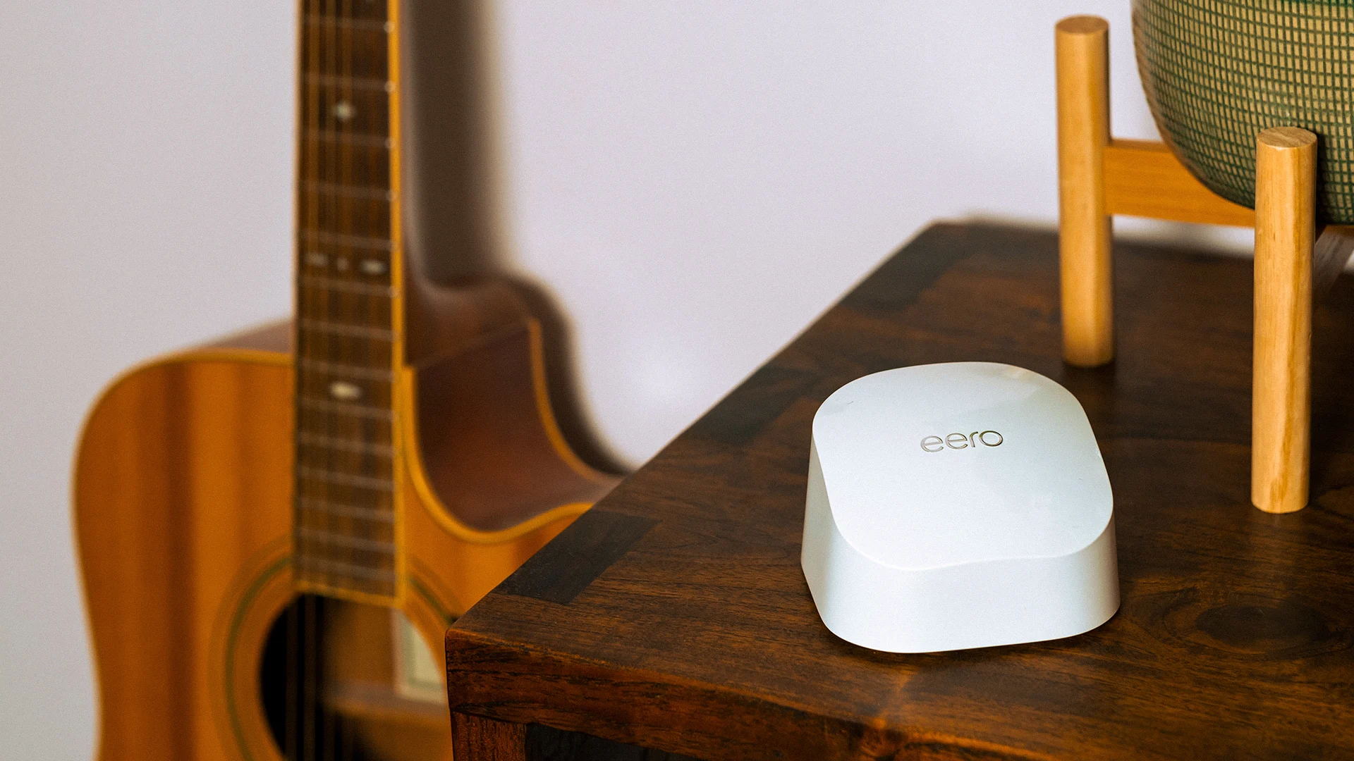 Eero Wi-Fi device positioned on a wooden table, representing whole-home Wi-Fi coverage and reliable broadband connectivity.
