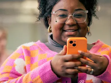 Mobile phone user staying connected through calls, messages and mobile internet services.