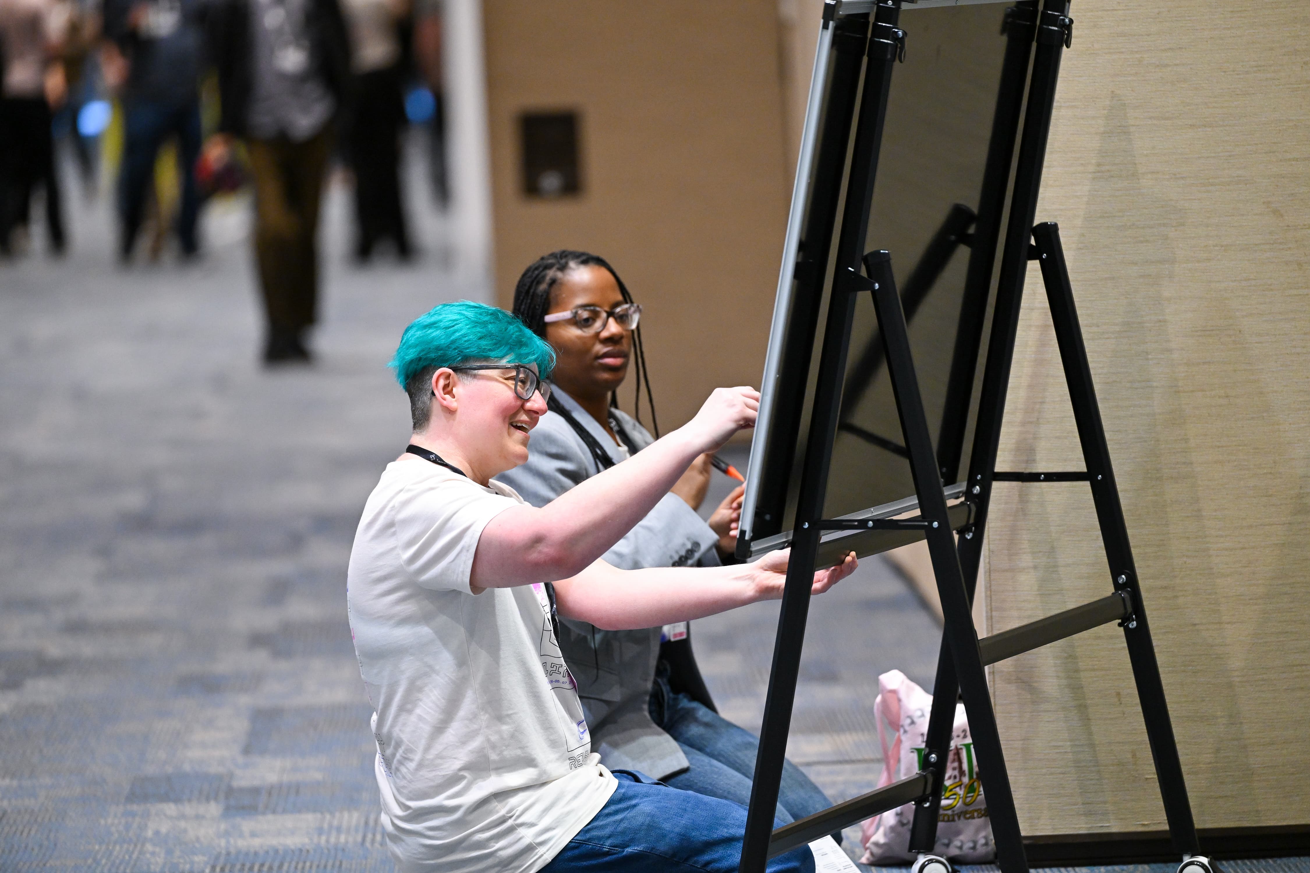 Two Replay 2026 attendees writing on a whiteboard
