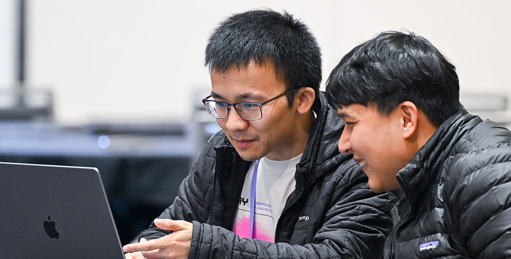 Two Replay workshop attendees looking at a laptop