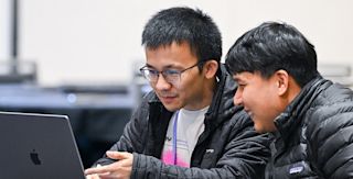 Two Replay workshop attendees looking at a laptop