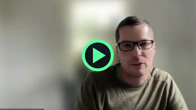 Video thumbnail showing a man wearing glasses and an olive green shirt with a green play button overlay in the center.