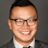 Professional headshot of an Asian man with black-framed glasses, mohawk hairstyle, wearing a gray suit and striped tie.