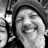 Black and white selfie of smiling bearded man in knit hat with child wearing Denver Nuggets beanie indoors with plants.