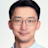 Professional headshot of an Asian man with glasses and dark hair wearing a light blue collared shirt against a white background.