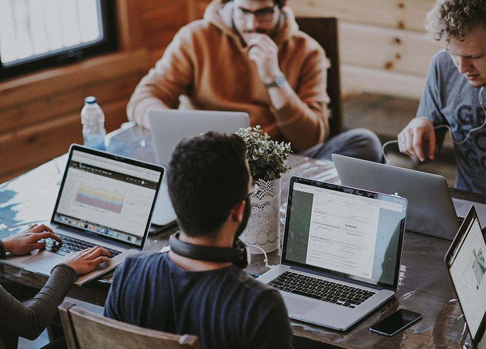 Men working in a room on their laptops