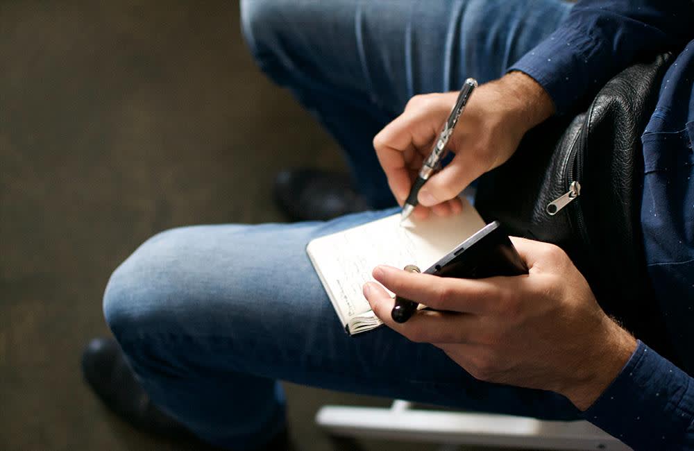 Man Writing in Notebook
