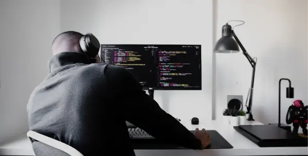 Man Coding with headphones