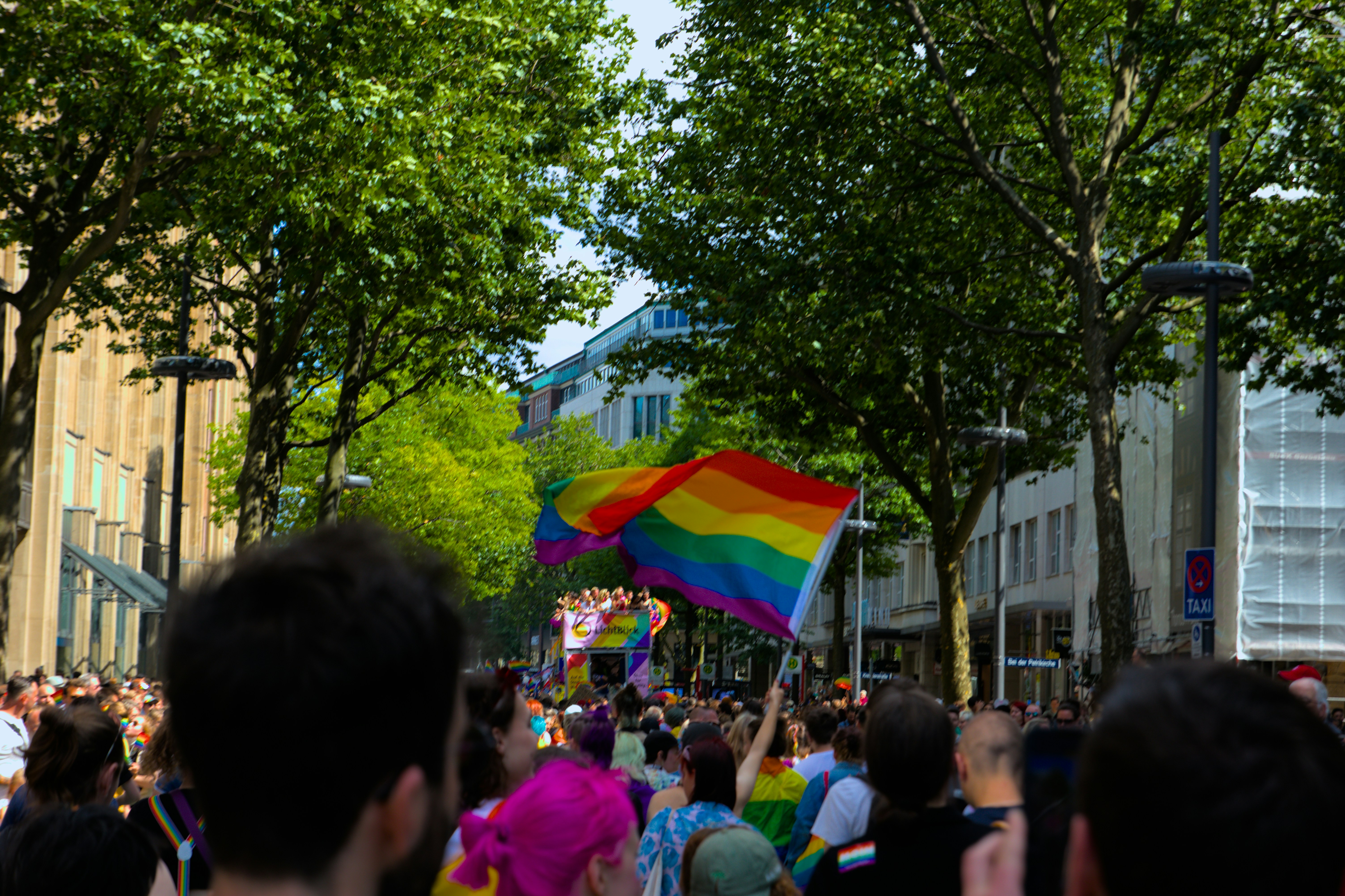 Rainbow Flag in the center of a pride parade march. 