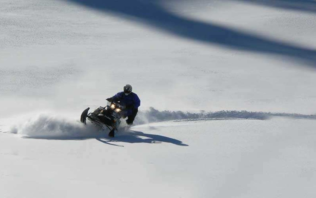Backcountry Snowmobiling | Photo Gallery | 4 - Snow-Capped Peaks & Powder Fields We don’t just take you to a field to ride snowmobiles around in circles, our snowmobiling tours venture through a vast expanse of terrain through snow capped peaks and powder fields of the Uinta mountains.