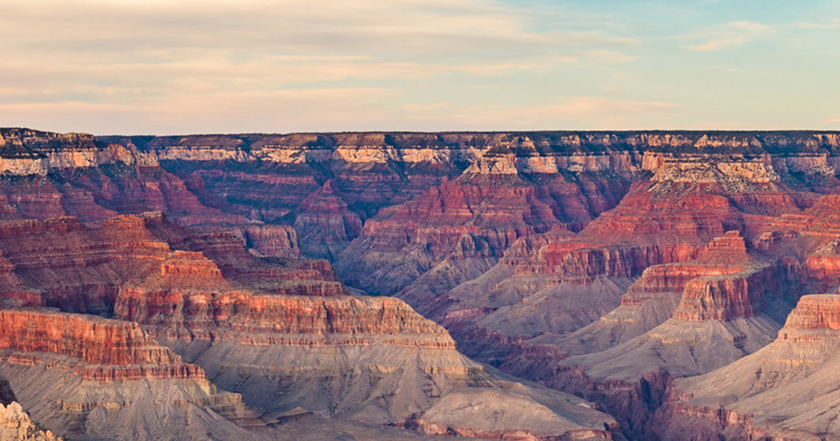 A breathtaking view of the Grand Canyon at sunrise, showcasing the vast landscape and colorful rock formations